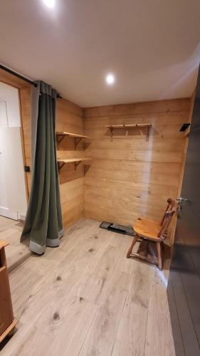 Cette chambre est dotée d'un mur en bois et d'une chaise en bois. dans l'établissement Karibu, à Saint-Gervais-les-Bains