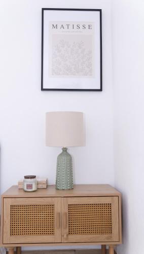 a table with a lamp and a picture on the wall at Casa Alagoa in Montemor-o-Velho