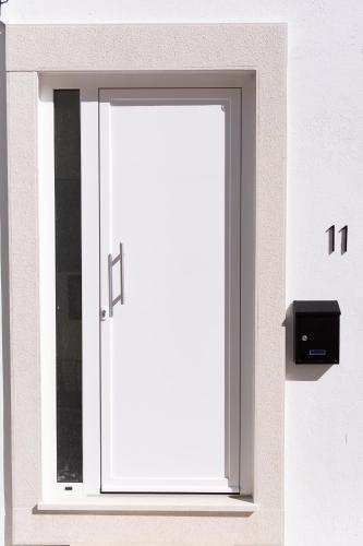 a white door on the side of a building at Casa Alagoa in Montemor-o-Velho
