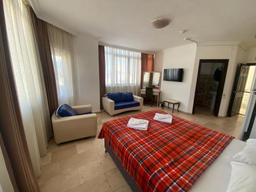 Una habitación de hotel con una cama y una sala de estar. en Hotel Alanya, en Alanya