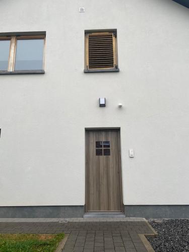 a door on the side of a white building at Entire fully equipped apartment in Stavelot