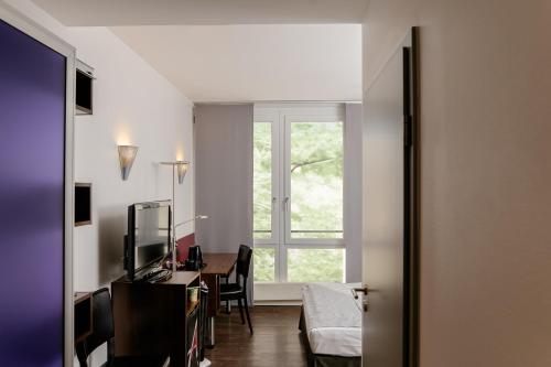 Télévision ou salle de divertissement dans l'établissement Auszeit Hotel Düsseldorf - das Frühstückshotel