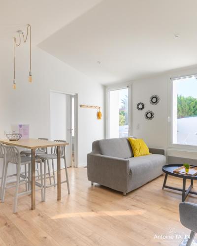 un salon avec un canapé et une table dans l'établissement Barbâtre - Les Figuiers, à Barbâtre