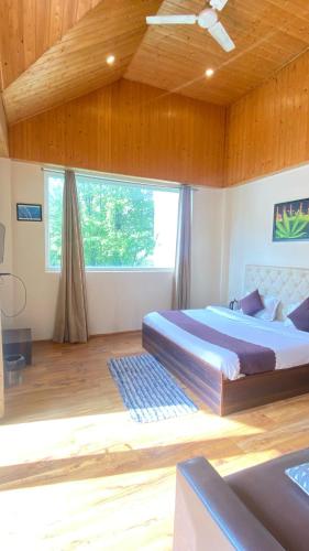 a bedroom with two beds and a large window at Hotel sissu - luxury rooms with rooftop restaurant in Sissu
