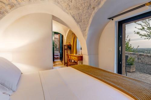 a bedroom with a bed and a window at CRIO - Experiences at home in Cisternino