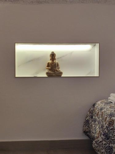 a mirror on a wall with a statue on it at Cueva Virgen de las Nieves in Monachil