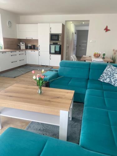 a living room with blue couches and a coffee table at Vila Mima in Nová Lesná