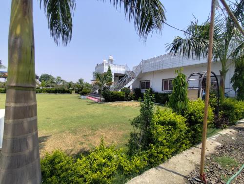 a house with a palm tree and a yard at Hotel Govindam Resort in Golāna