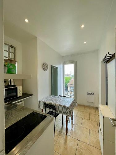 una cocina con una mesa y una mesa pequeña. en Studio tout confort proche Gare RER D, en Goussainville
