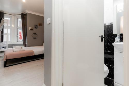 a small bedroom with a bed and a bathroom at Orlando hotel in London