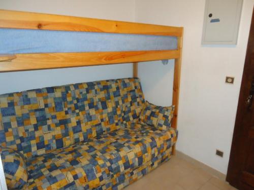 - un lit dans une chambre avec un canapé dans l'établissement joli studio rez de jardin résidence avec piscine, à Cavalaire-sur-Mer