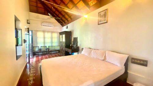 una camera da letto con un letto bianco in una stanza di Udupi Heritage a Udupi
