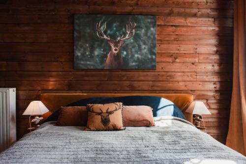 a bedroom with a bed with a deer painting on the wall at Maison d'hôtes Les Notes Endormies in Walcourt