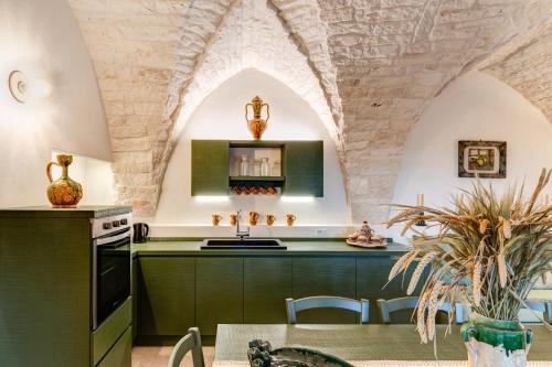 a kitchen with green cabinets and an arched ceiling at CRIO - Experiences at home in Cisternino