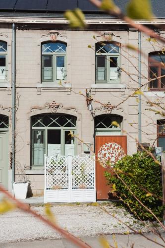 a house with a white door and a gate at Maison d'hôtes Les Notes Endormies in Walcourt