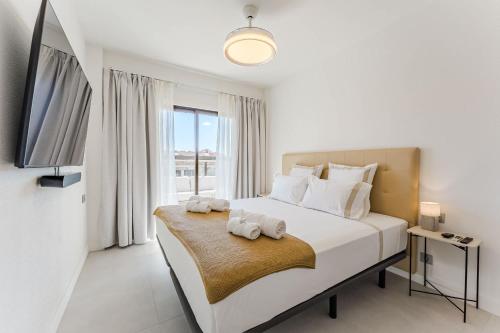 a white bedroom with a bed with towels on it at Atlantic View Premium Oceanfront Suite in Costa Del Silencio