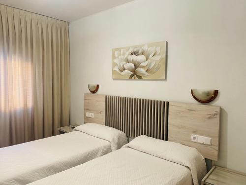 a hotel room with two beds and a painting on the wall at Hotel Praderón in San Sebastián de los Reyes