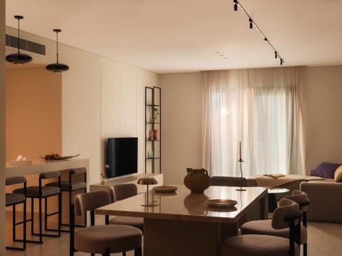 a living room with a table and chairs and a couch at Brassbell Zamalek Diplomatic Zone Near Marriott in Cairo