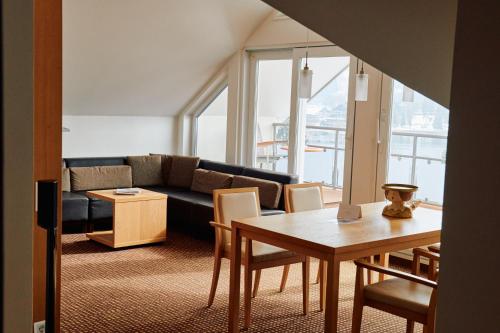 a living room with a couch and a table at BRUGGER'S Hotelpark am See in Titisee-Neustadt