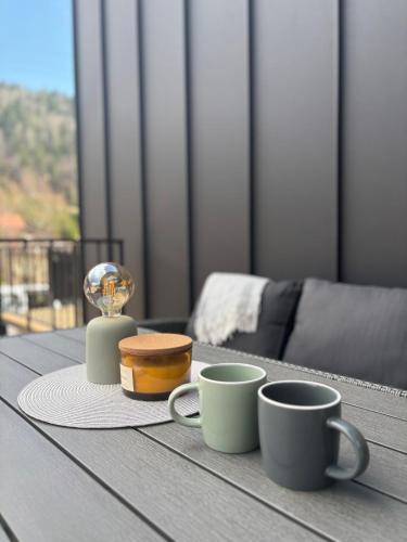 a table with two coffee cups and a cake on it at Cabins Dolce Vita in Konjska Reka