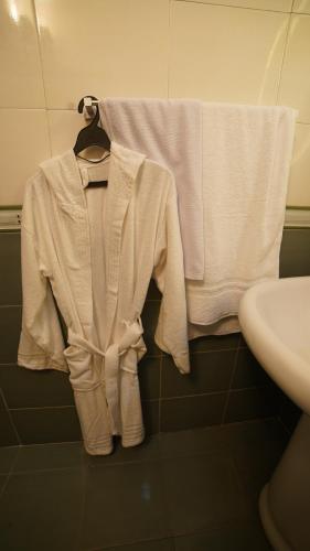 a white shirt and towel on a rack in a bathroom at Service Apartment by World Inn in Karachi