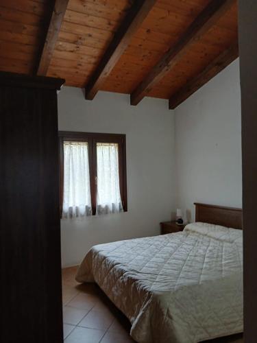 a bedroom with a bed and two windows at Da Nonna Maria Ozieri in Ozieri