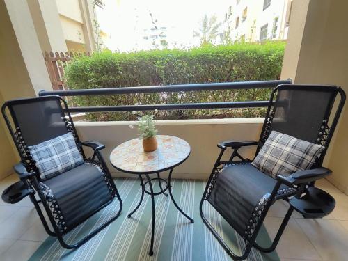 duas cadeiras e uma mesa em uma varanda em Luxury 2 BD, A Midtown Quintessential Community em Sabkhah