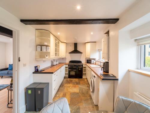 a kitchen with white cabinets and a stove top oven at Cosy 2 Bed Terrace Peaceful Village location - Pass the Keys in Oxford