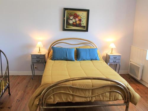 une chambre avec un grand lit avec des oreillers bleus dans l'établissement Charmante maison, jardin paysagé, piscine, proche sites préhistoriques et Sarlat - FR-1-616-195, à Pazayac