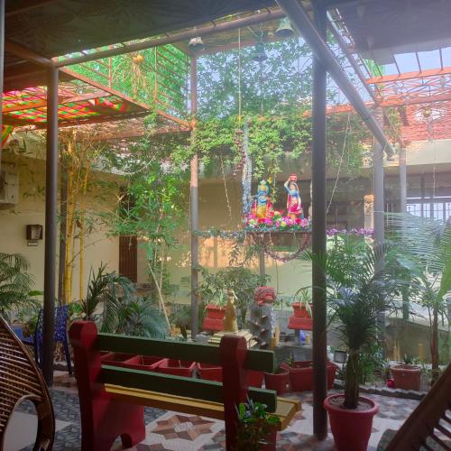 a patio with a lot of plants and trees at Maha Periyava Kuteeram in Kumbakonam