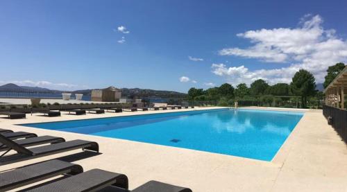 - une grande piscine avec des chaises longues à côté dans l'établissement T2, Picculu - Jardín, piscina, 4 pers, parking, à Porto-Vecchio