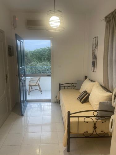 a bedroom with a bed and a view of a balcony at Studio Mare in Megalochori