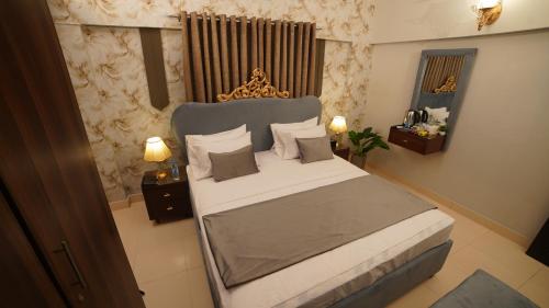 a bedroom with a large bed in a room at Service Apartment by World Inn in Karachi