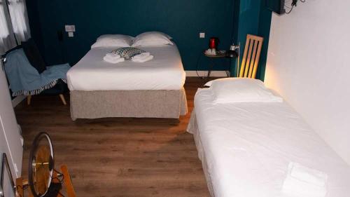 two beds in a small room withthritisthritislictslictslicts at Hôtel Le petit billot in Vitré