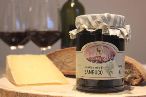 a jar of jam with cheese and a bottle of wine at Agli Chalet Bosco in Domodossola