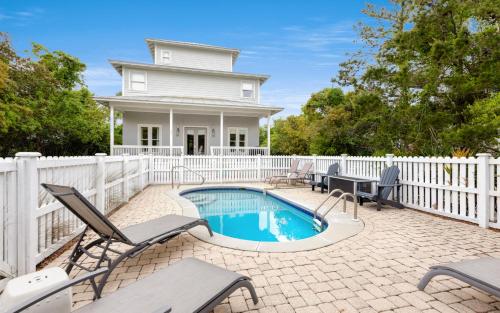 a house with a swimming pool and a white fence at Ritz Clareon by Oversee 30A in Seacrest