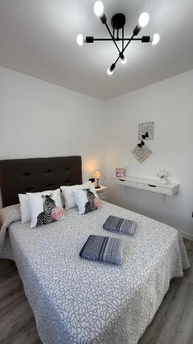 a bedroom with a bed with two pillows on it at Apartamento Florkin vacacional acogedor recién reformado con vistas al mar in Torrox