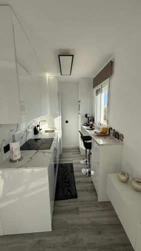 a white kitchen with a sink and a counter at Apartamento Florkin vacacional acogedor recién reformado con vistas al mar in Torrox
