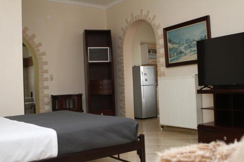 a bedroom with a bed and a refrigerator and a television at Fertoun apartment in Chaïdeftón