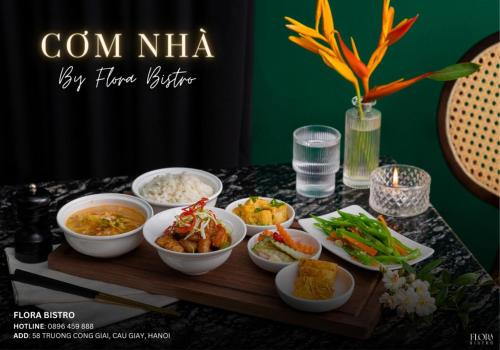 a table topped with bowls of food on a table at Bloom in Hanoi - The Residences in Hanoi