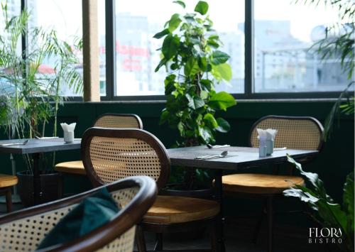 a row of tables in a restaurant with plants at Bloom in Hanoi - The Residences in Hanoi