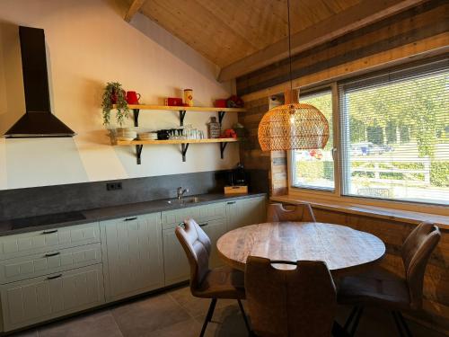 a kitchen with a table and chairs and a window at HoeveLieshout - Lux 4 persoons platteland appartement in Weert