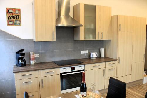 a kitchen with wooden cabinets and a stove top oven at Ferienwohnung Ostersander - zentral gelegen zwischen Ihlow, Timmeler Meer, Aurich und der Wassersportanlage in Tannenhausen in Ihlow