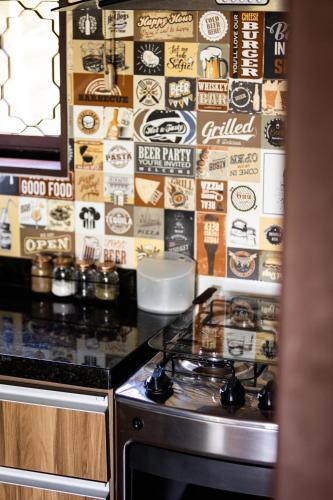 a kitchen with a stove and a wall of signs at Villaggio dos Pássaros in Paranoá