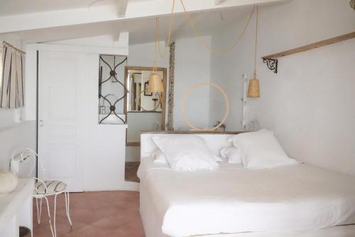 a white bedroom with a white bed and a mirror at Hôtel Lido Beach in Hyères