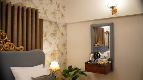 a bedroom with a bed and a mirror and a table at Service Apartment by World Inn in Karachi