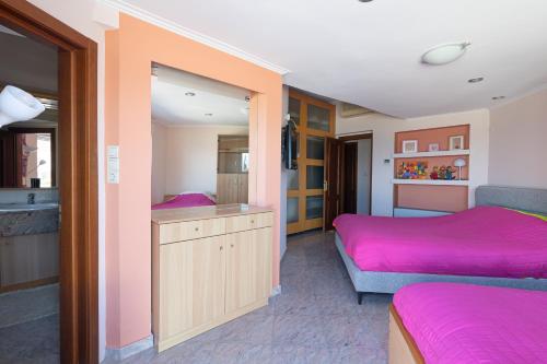 1 Schlafzimmer mit 2 Betten und rosa Bettwäsche in der Unterkunft LIVAS Corinth Seaside Family Apartment in Kórinthos
