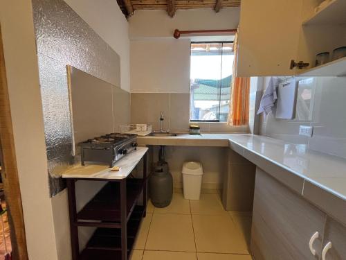 y cocina con fregadero y fogones. en "CASITA DE GERANIOS " con cocina , sala , patio amplio y cochera privada, en Chivay