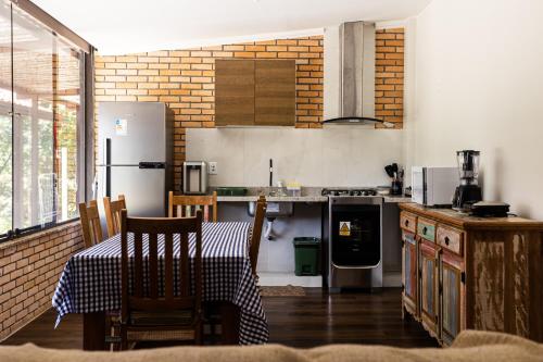 a kitchen with a table and a refrigerator at Villaggio dos Pássaros in Paranoá