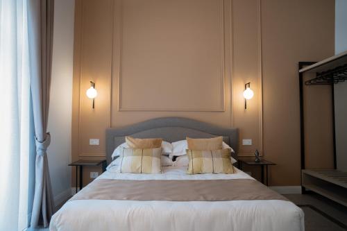 a bedroom with a large bed with pillows at Monteroduni 22 - Chiaia Design Rooms in Naples